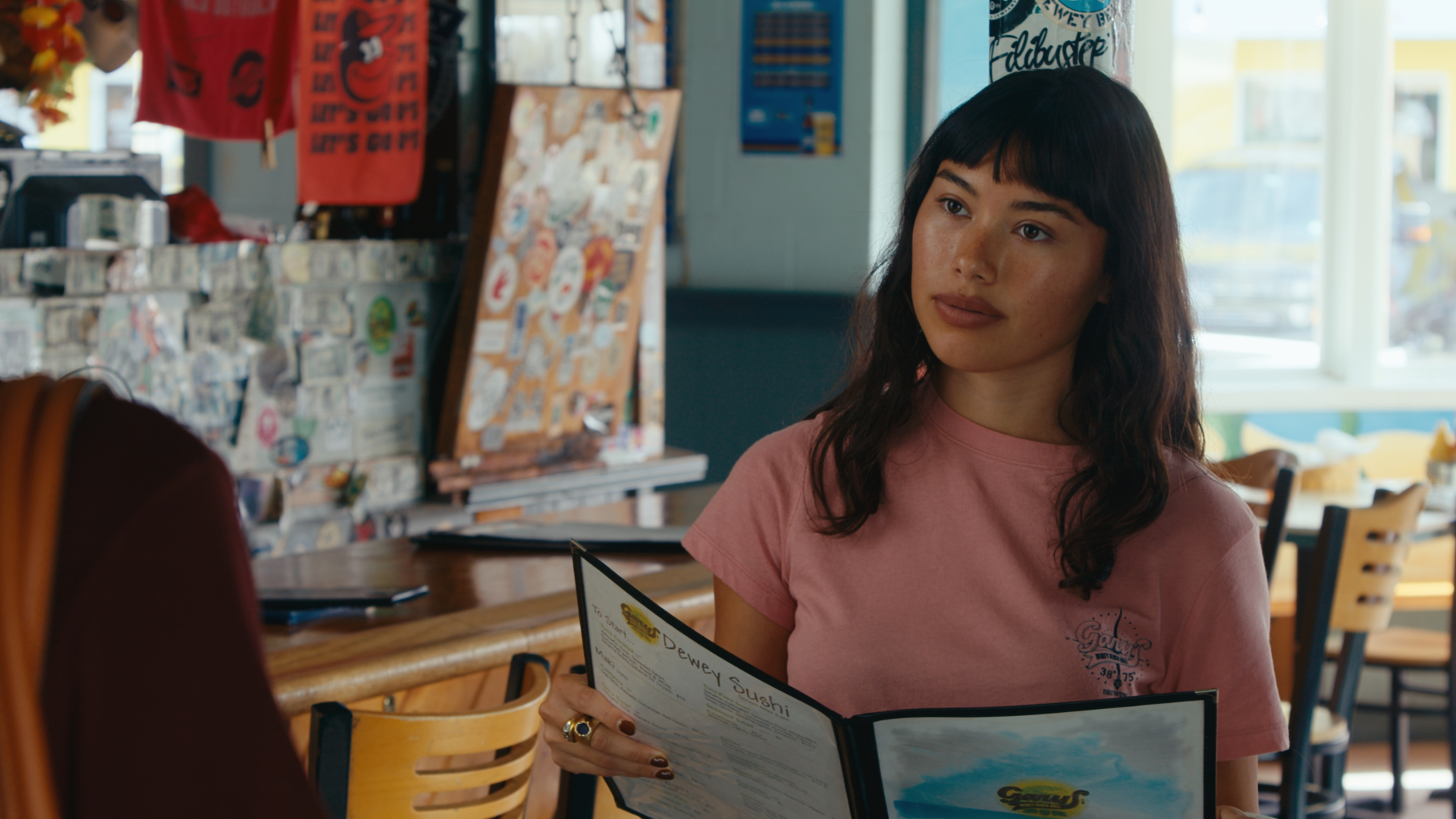 A waitress in a pink Gary's shirt holding a menu in the dining room