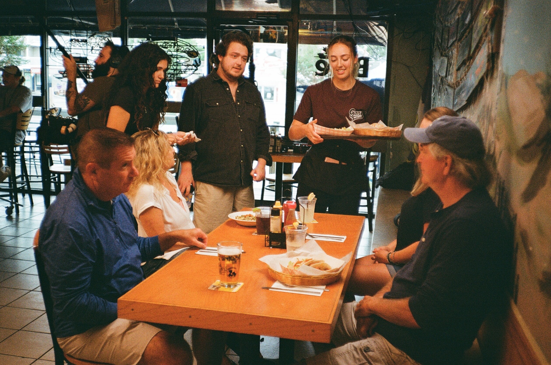 Behind the scenes — a server delivering food on set inside Gary's