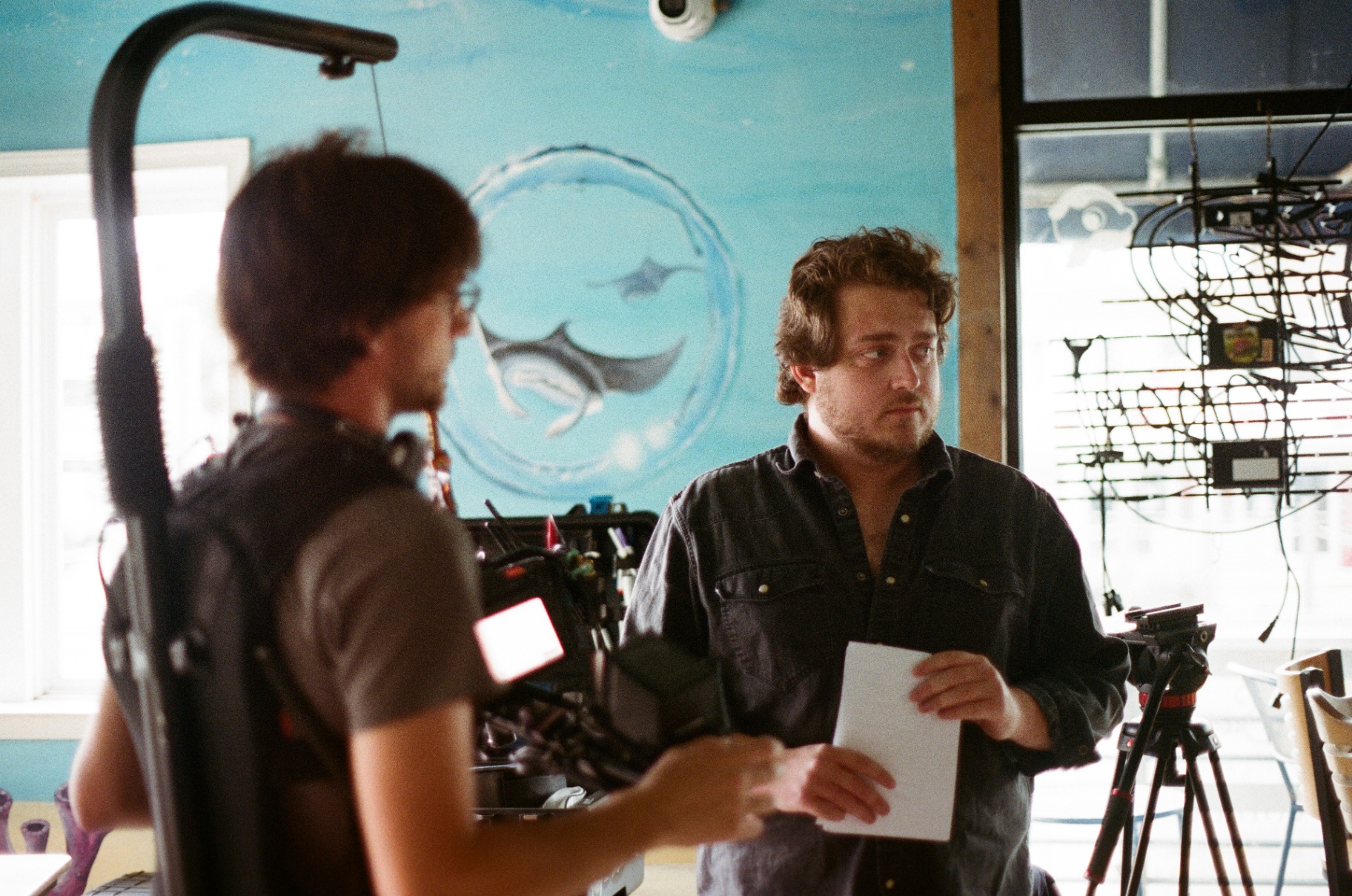 Director Zach on set in front of a painted ocean mural.