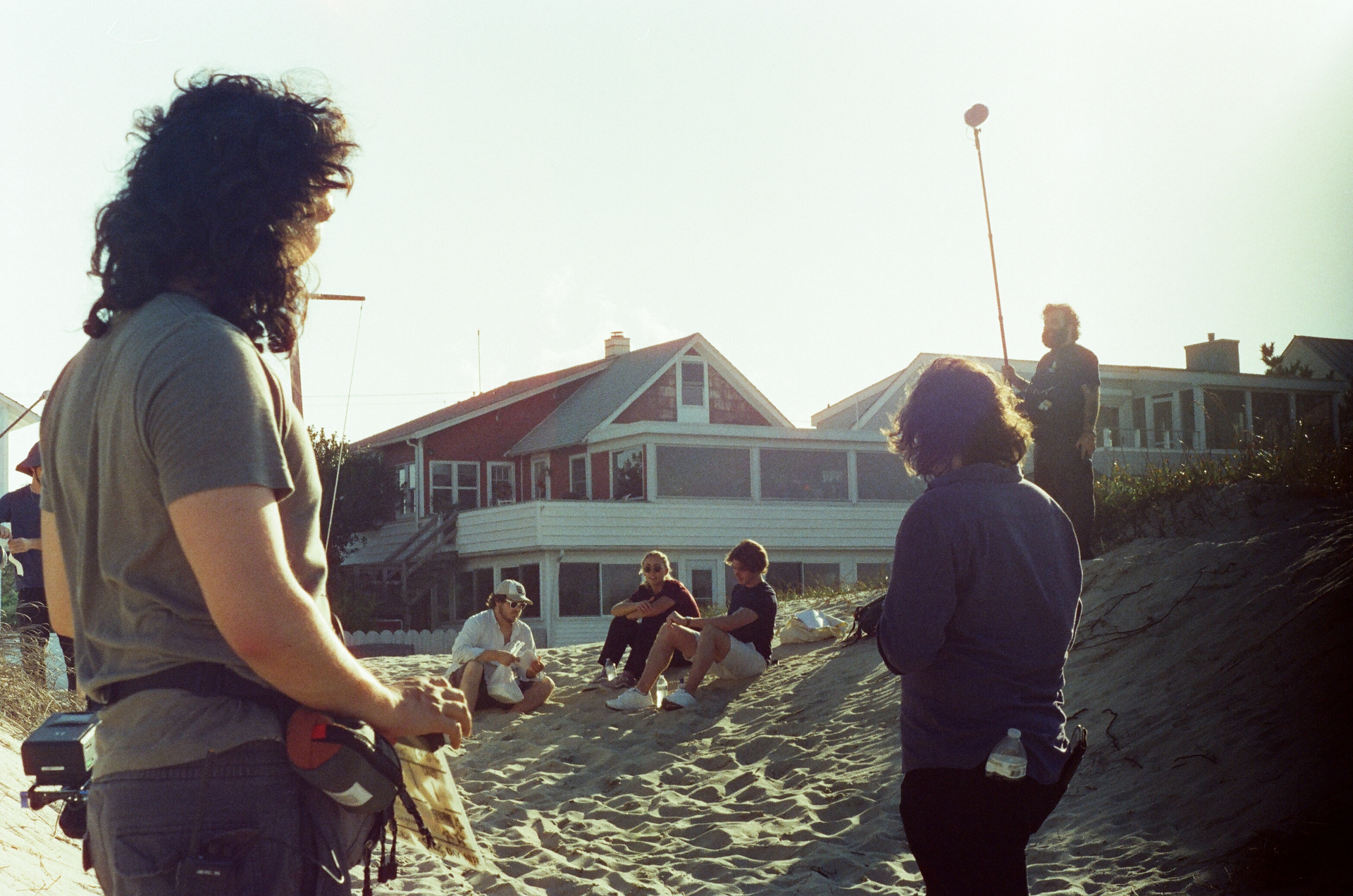 Behind the scenes — crew filming a scene on the dunes at golden hour